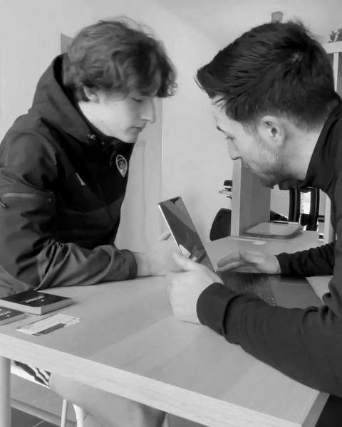 Kinésithérapeute qui commente les résultats de tests sur une tablette avec un jeune sportif